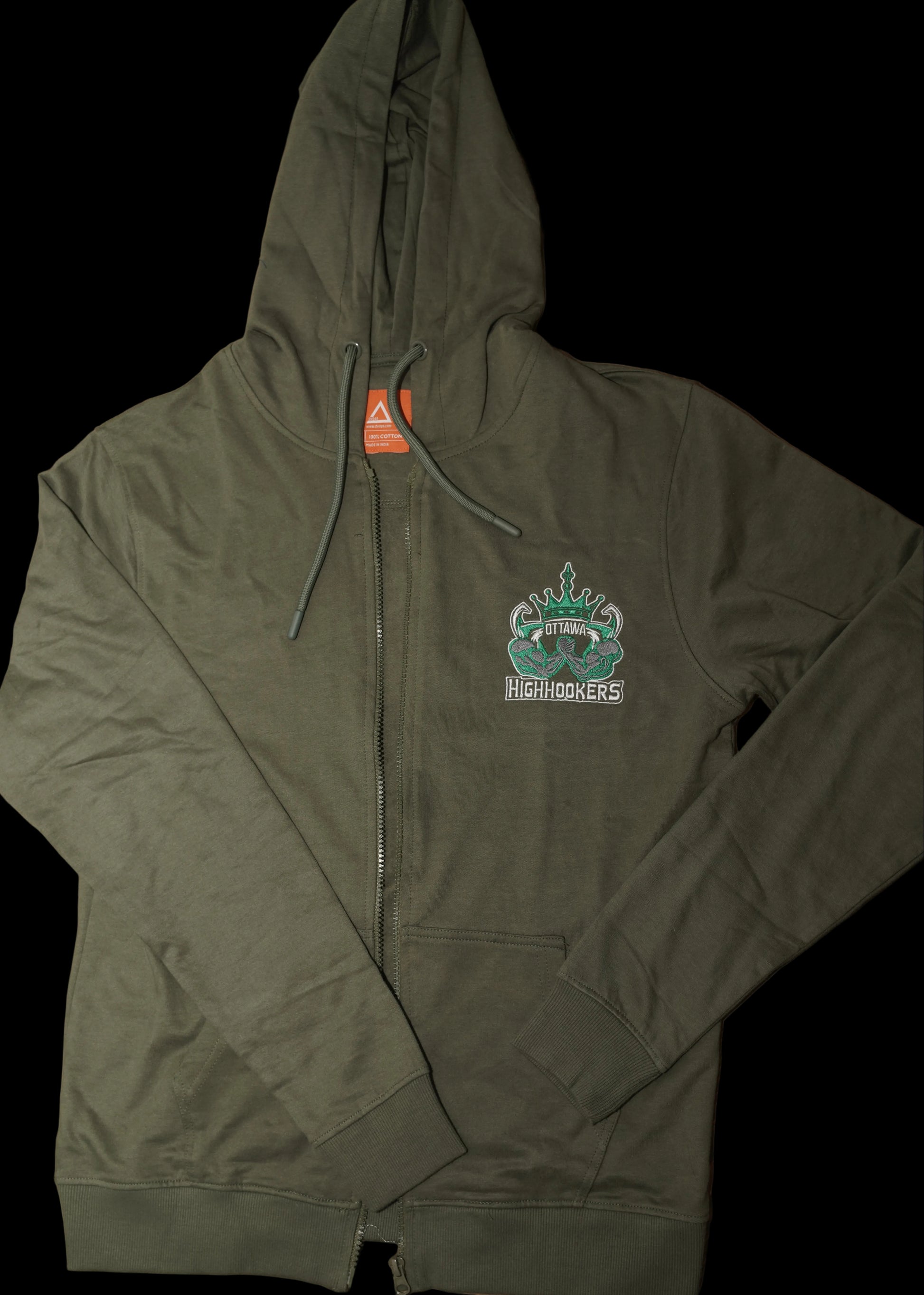 An olive green zip-up hoodie laid flat on a wooden table, featuring a small graphic on the left chest \