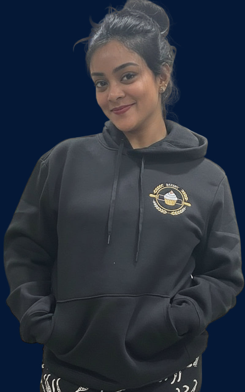 Person wearing a black hoodie indoors with a neutral background